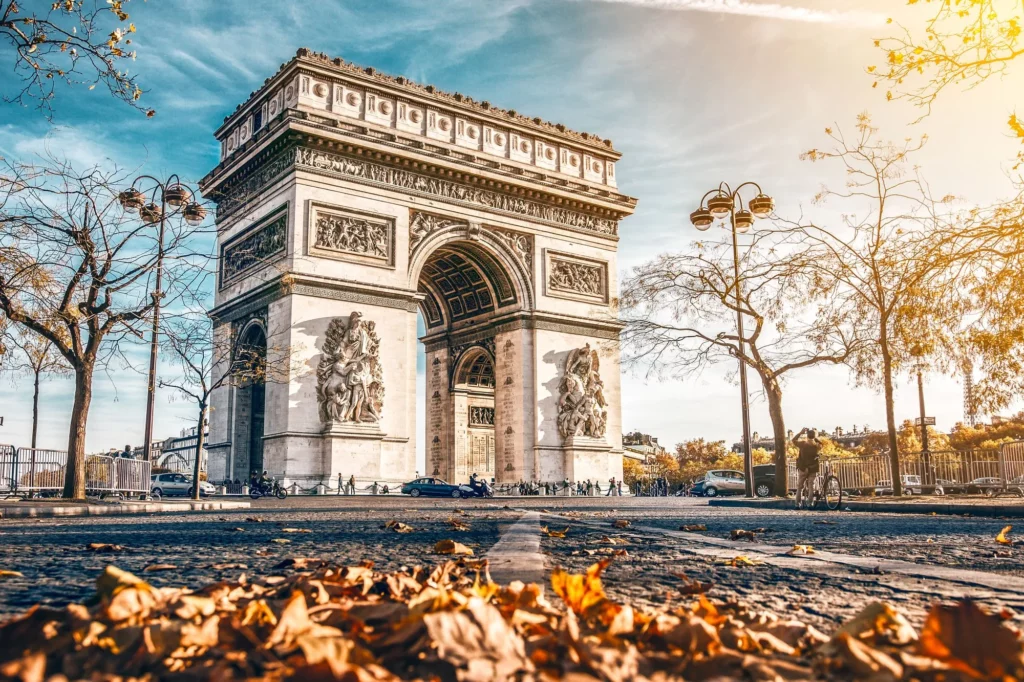 A view of the majestic Arc de Triomphe, standing proudly at the center of a bustling Parisian intersection.